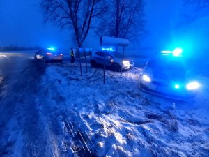 Na zdjęciu widoczny zaśnieżony odcinek drogi publicznej gdzie znajdują się unieruchomione pojazdy biorące udział w kolizji drogowej.