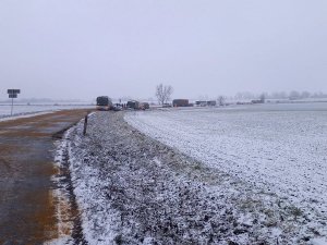 Na zdjęciu widoczny zaśnieżony odcinek drogi publicznej gdzie znajdują się unieruchomione pojazdy biorące udział w kolizji drogowej.