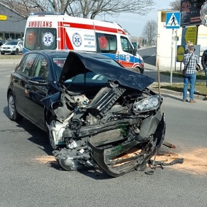 Na zdjęciu widoczny samochód osobowy, który brał udział w kolizji drogowej. W tle zabudowania gospodarcze oraz drzewa.