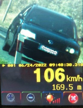 Na zdjęciu widoczny samochód osobowy koloru ciemnego, poniżej widoczna aktualna prędkość 106 km/h, tuż obok prędkość dozwolona tj. 50 km/h