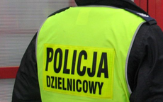 Na zdjęciu widoczny umundurowany policjant z założona kamizelką odblaskową z napisem DZIELNICOWY.