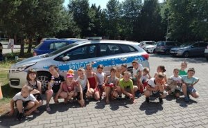 Na zdjęciu widoczny umundurowany policjant w obecności dzieci klas 1. 
Poniżej rysunki przekazane policjantowi przez dzieci poszczególnych klas.